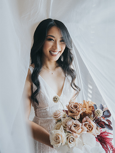 bride dressed in wedding gown, holding wedding bouquet
